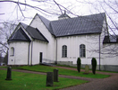 Näsby kyrka sedd från nordost med de medeltida delarna till vänster och nykyrkan och vapenhuset till höger.