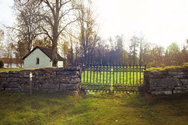 Den medeltida kyrkogården med smidesgrind och sakristia sydöst om Dalstorps kyrka.