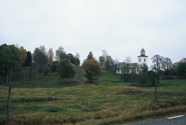 Gillberga kyrka från nordväst, med järnåldersgravfältet norr om kyrkan.