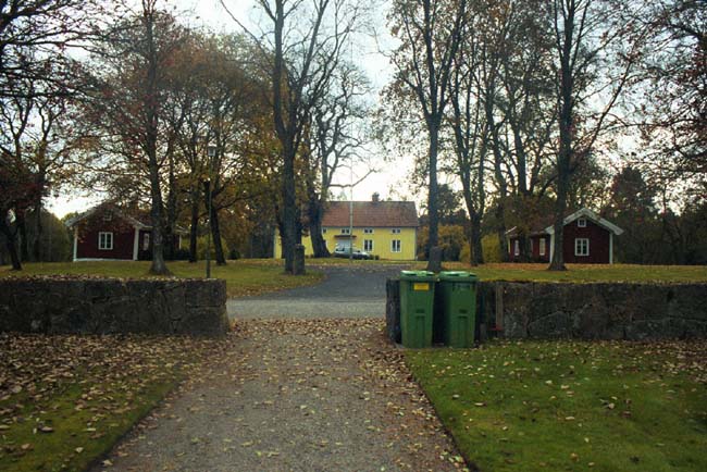 Öppning i södra kyrkogårdsmuren mot prästgården söder om Dalstorps kyrka.