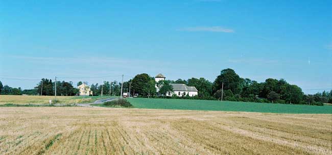 Miljön vid Gestads kyrka från söder. Till höger kyrkan och till väster den f d prästgården, nu församlingshem.  