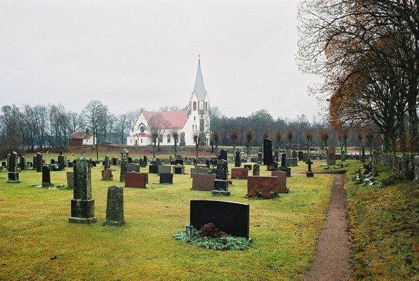 Kyrkogården norr om Kalvs kyrka med kyrkan i fonden, från NÖ.