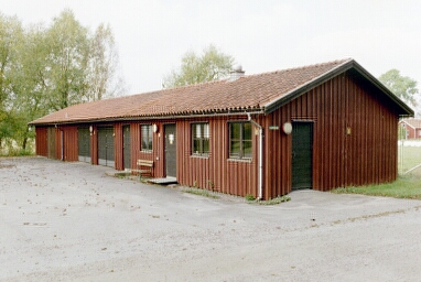 Vid parkeringen nordväst om Vassända-Naglums kyrka finns dess långsträckta ekonomibyggnad..