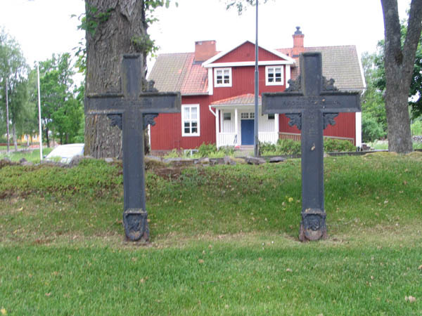 Uppställda gjutjärnskors i kvarter J. I bakgrunden f.d.
skolhus som idag är församlingshem. 