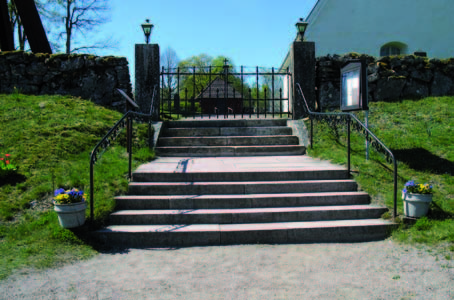 I öster leder en trappa upp mot en öppning i stenmuren och huvudingången
till kyrkogården.