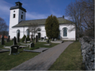 Rådmansö kyrka från sydväst. Kyrkogården med ett större antal grusade
ligger i sydsluttningen mot vattnet och omgärdas av bogårdsmur.
