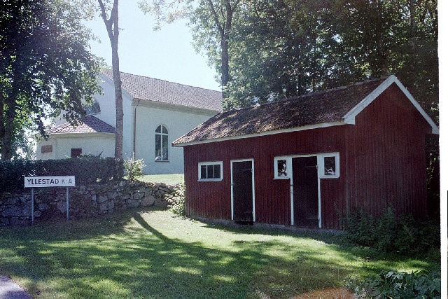 Yllestads kyrka ekonomibyggnad med kyrkan i bakgrunden. Negnr 01/272:25