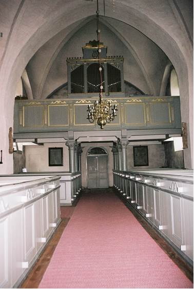 Kyrkorummet åt väst med läktarbärriär med förgyllda pilastermotiv buren av grå pelare med kapitäl. Orgelfasaden är utförd år 1876 och hållen i grått med förgyllda detaljer