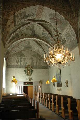 Långhuset med bänkarna och armaturerna gjorda av Lundberg tillsammans med de medeltida takmålningarna. 