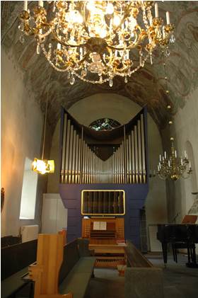 Orgeln i den norra korsarmen, bakom den skymtar glasmålningen. 
