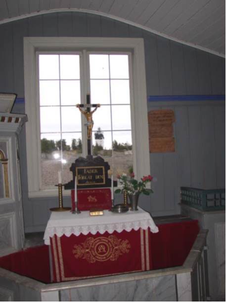 Detalj av altaret, altarringen och kapellets fönster mot öster med fyren i blickfånget.