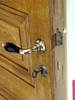 Detalj av dörren till sakristian. Snickerierna är ekådrade enligt 1890-talets mode. Här är
dessutom den tidens lås bevarat, inklusive nyckel och förnicklat handtag med trägrepp.