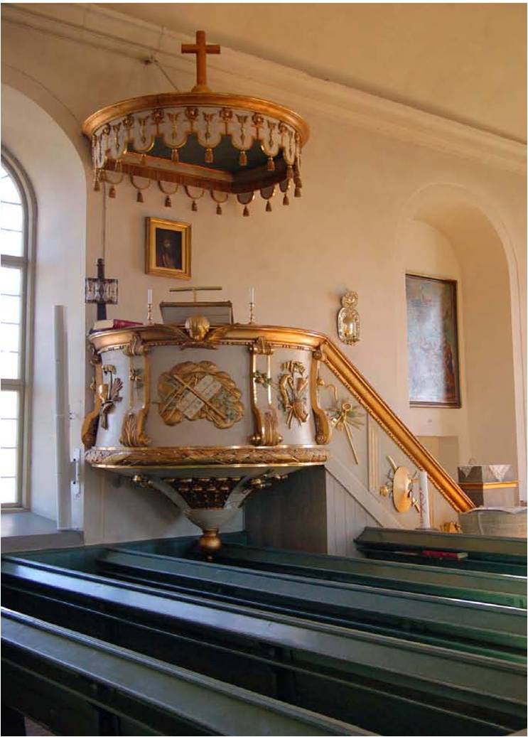 Predikstolen av F B Blombergsson är utförd i tidstypisk empirestil med förgyllda detaljer mot en neutralt grå botten.