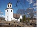 Alsike kyrka från sydväst. Kyrkogården omges av en trädkrans med ovanligt stora, gamla lövträd. 