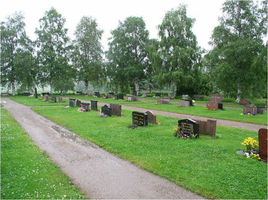 Låga stenar med enkel utsmyckning, mellan raka grusgångar, öster om kyrkan. I bakgrunden syns trädkransen av björk