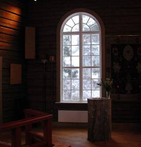 Stora fönster, nakna timmerväggar och en naturromantisk
dopfunt av urholkad tallstam.