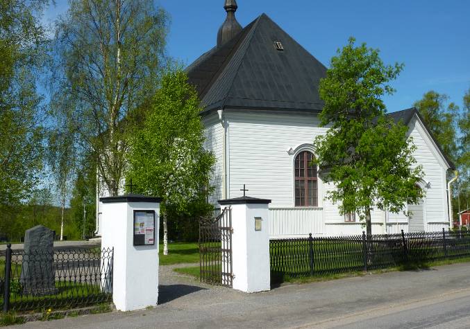 Grindstolparna från 1850-talet och det sirliga järnstaketet från tidigt 1900-tal ger en fin inramning till kyrkomiljön. I bakgrunden skymtar den snedställda sakristian och det östra korfönstret som sedan 1922 är blindfönster.