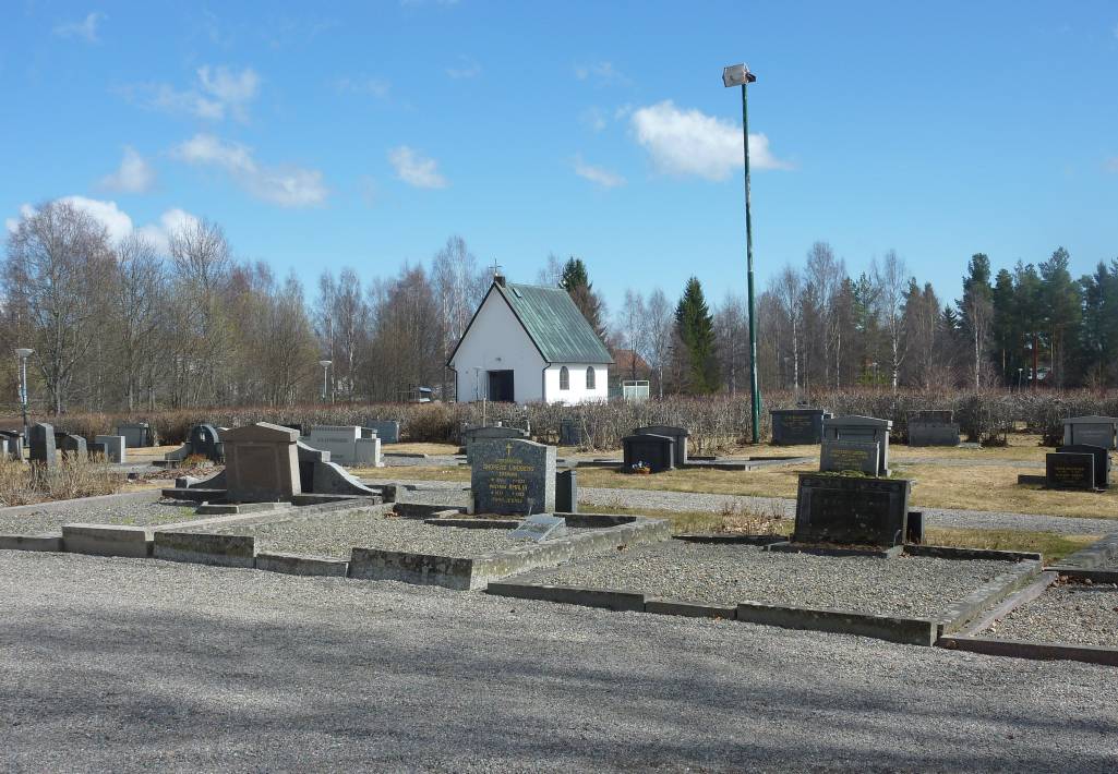 Närmast öster om kyrkan finns ett flertal grusgravar med stenramar. I övrigt avgränsas gravkvarteren på tidstypiskt 1930-talssätt av rygg-häckar av måbär. I bakgrunden skymtar grav-kapellet från 1931.