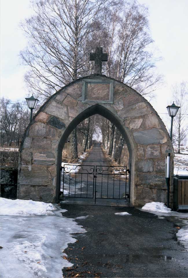 Stigen genom stigluckan på den norra delen av kyrkogården leder i rät linje upp mot prästgården.