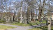 Kyrkogården anlades ursprungligen som lasarettskyrkogård omkring 1800, och på andra sidan Storgatan (tidigare Kustlandsvägen) finns fort-farande länets äldsta lasarett kvar (den gula byggnaden ovan). Denna begravningsplats är rikast i länet på påkostade gravmonument. Här ligger många familjer av betydelse för Umeås historia.