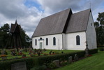 Mortorps kyrka med omgivande kyrkogård och klockstapel.