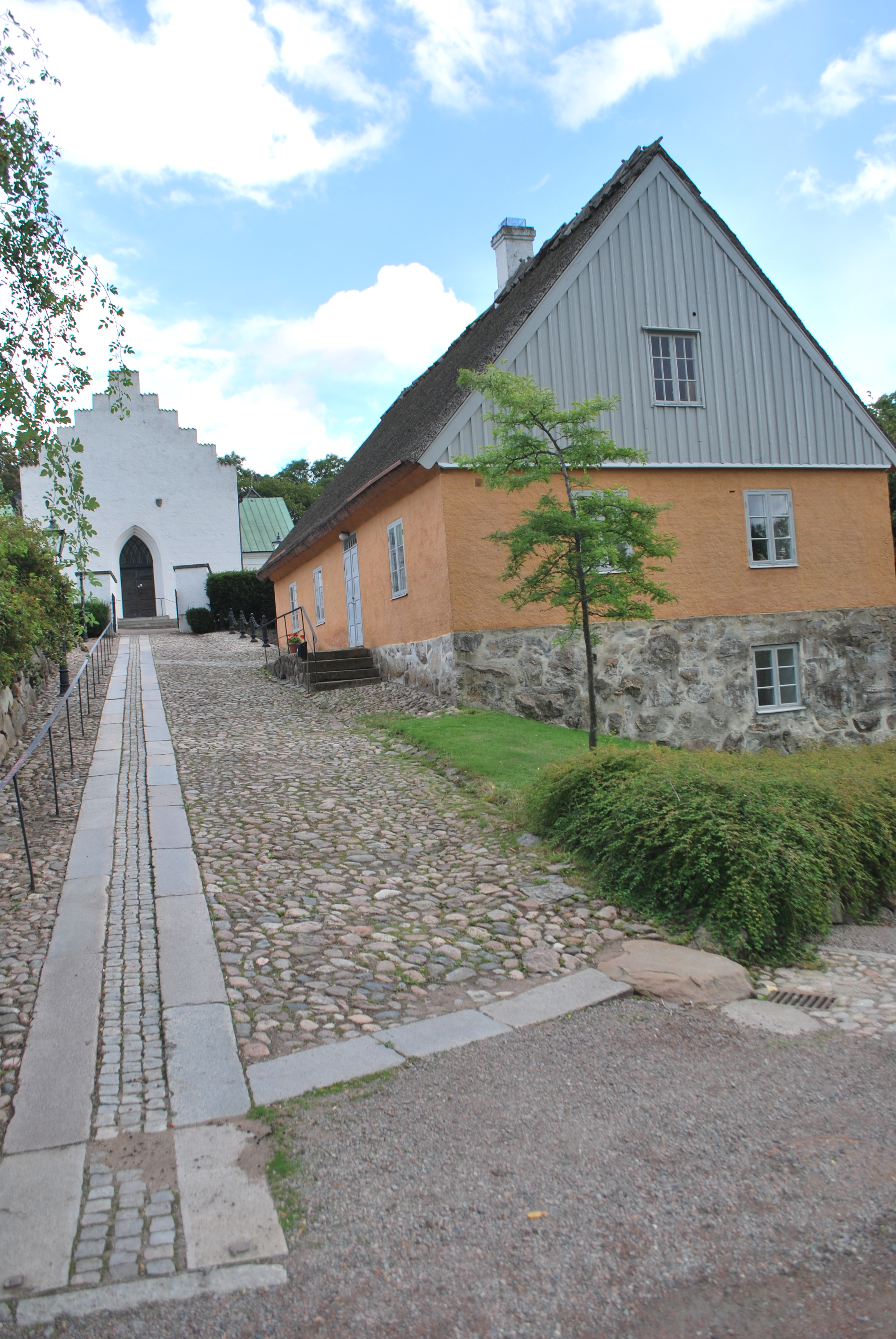Raus kyrka, kyrkans västfasad och f.d. skola
