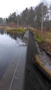 Dammen är en överfallsdamm helt i betong - här ses den ej reglerbara delen med fast tröskel och skibord. 