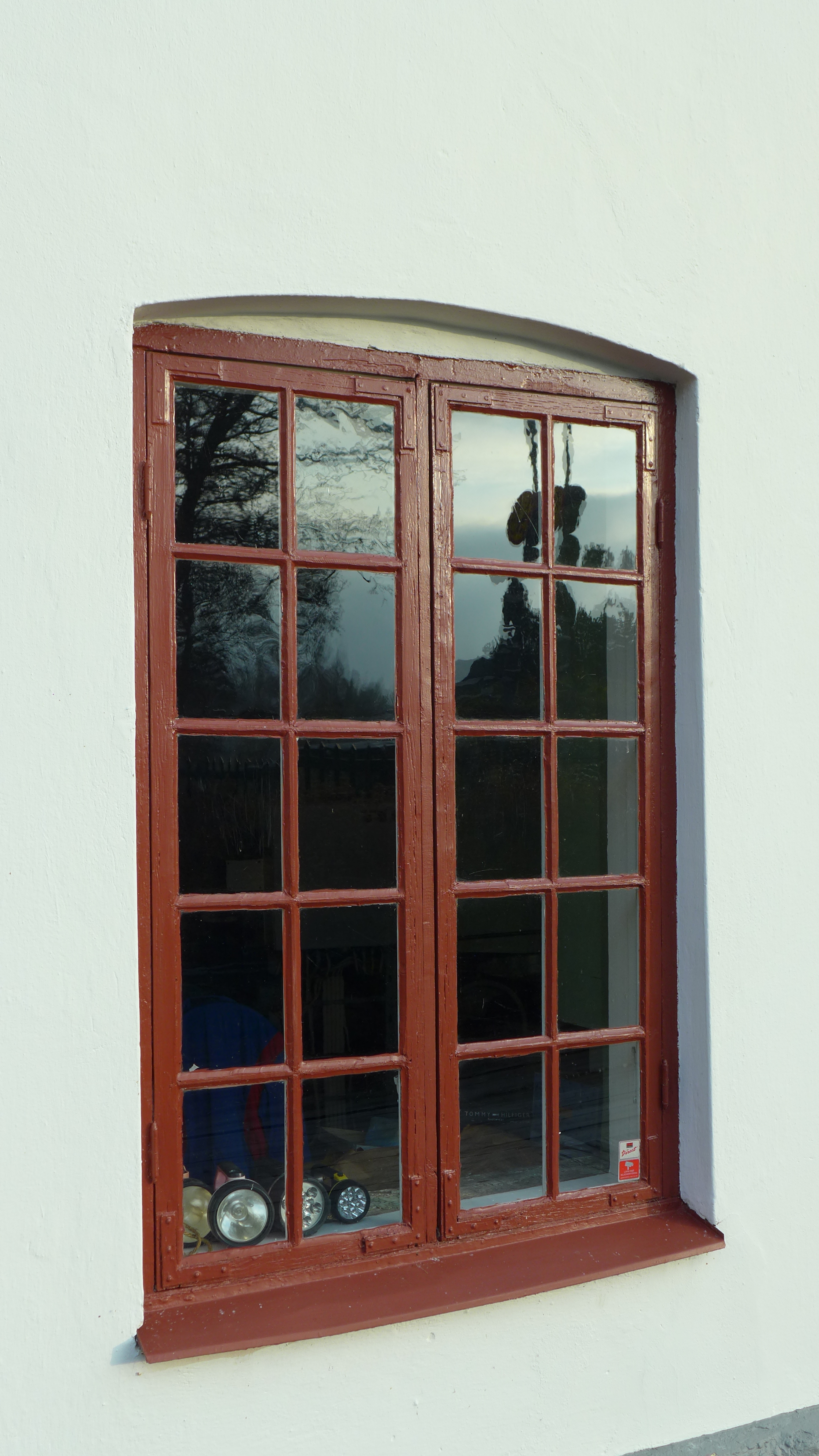Fönster och dörrar är av trä, målade i engelskt rött - vissa har segmentbågsform. 