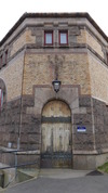 Huvudentrén är placerad vid byggnadens avfasade hörn. Porten är av massiv ek med smidda beslag i fornnordisk stil. 
