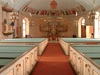 Kyrkorummet präglas i hög grad av 1900-talets omgestaltade kor och nya
färgsättning.