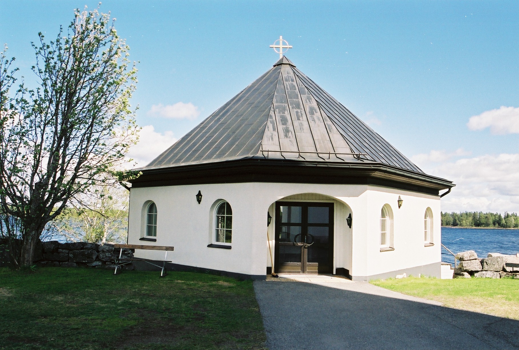 Hammerdals kyrkogård, strandkapellet.

Ett tiotal meter nordväst om tornet ligger ett sexkantigt gravkapell från 1990 i souterräng ned mot sjön. Sluttningsvåningen och sockelmuren är slätputsade och mörkt grå. Byggnaden är annars spritputsad och målad varmvit. Likkällaren har två dubbeldörrar och små spröjsade fönster medan huvudvåningen har flera rundbågiga moderna fönster. Ingången är belägen mot kyrkan och består av en inskjuten glasad aluminiumport. Byggnaden har koppartäckt tälttak och harmonierar i stort med kyrkan.

Bilderna är tagna av Martin Lagergren & Emelie Petersson, bebyggelseantikvarier vid Jämtlands läns museum, i samband med inventeringen, 2004-2005. 