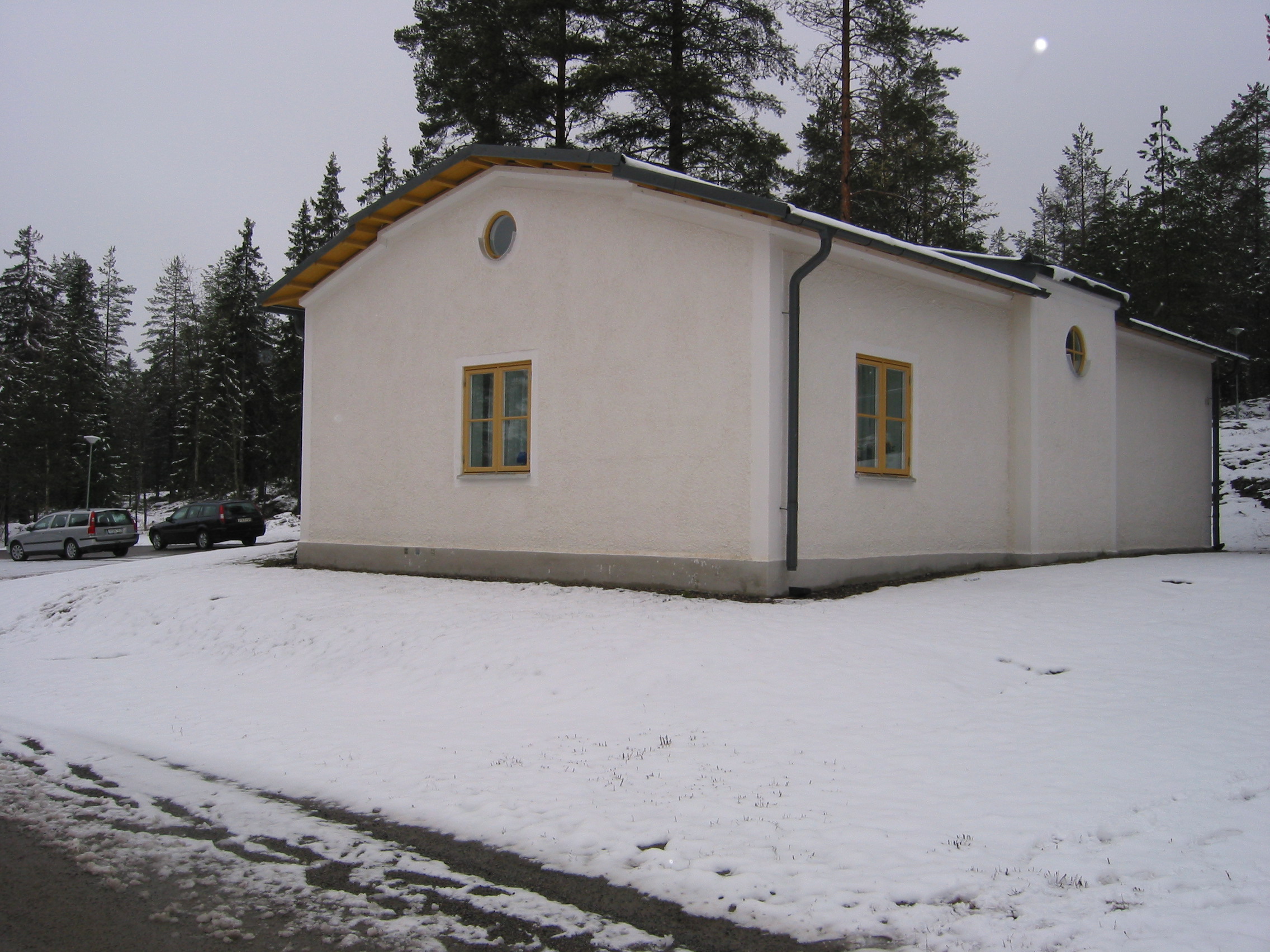 Hässjö kyrkas kyrkogård, det nya gravkapellet, vy från sydöst.

Norr om kyrkan passerar byvägen förbi kyrkan. Strax norr om den vägen finns ett gravkapell från sent 1990-tal. 

