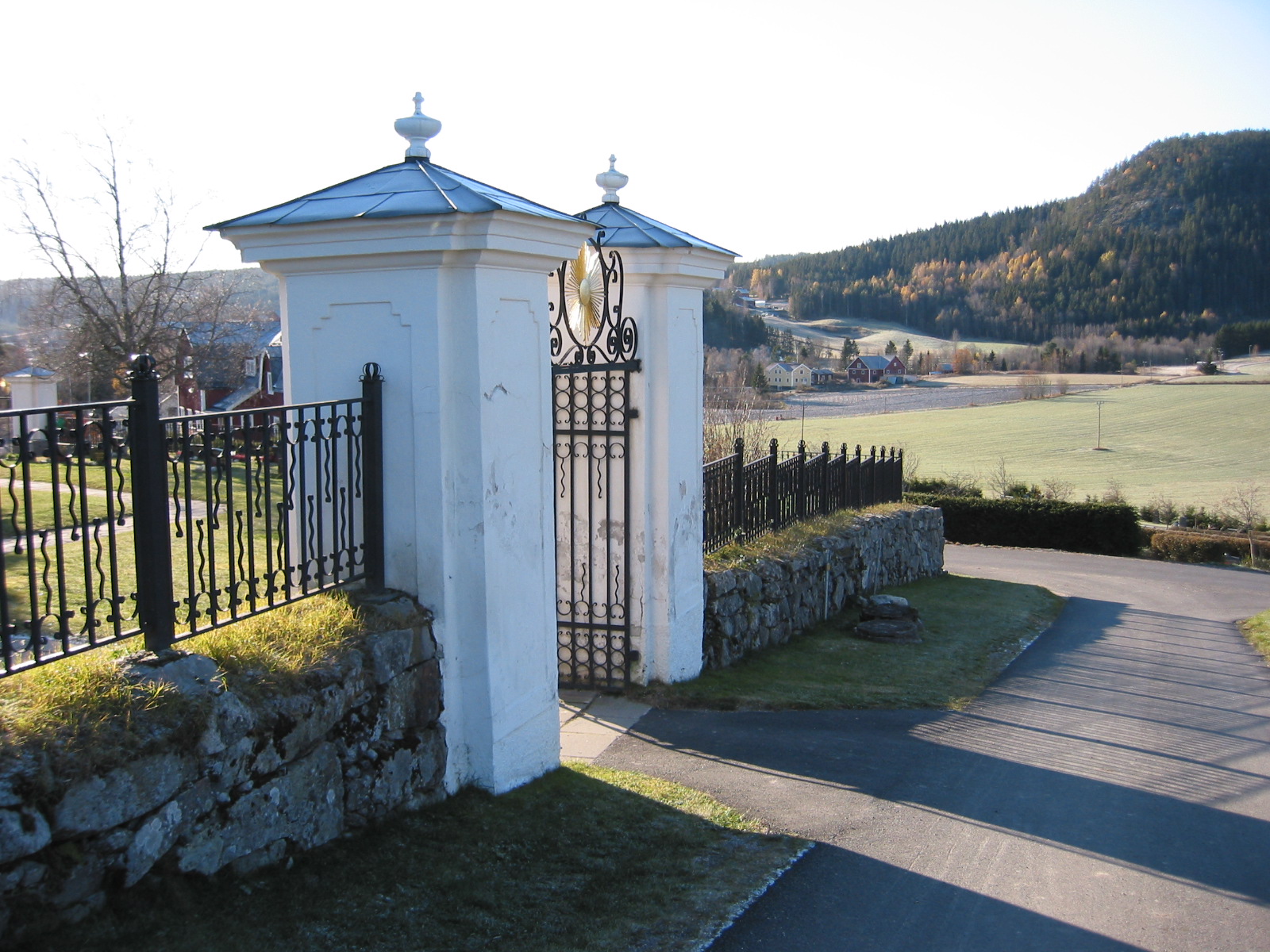 Ljustorps kyrkas kyrkogård, stigportarna.
Stigport i söder och väster, murade, slätputsade och vitmålade stolpar, avtäckta med falsad plåt. Mellan dem smidesgrindar med fast överstycke. 