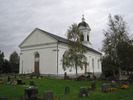 Ådals-lidens kyrka med omgivande kyrkogård, vy från sydväst.