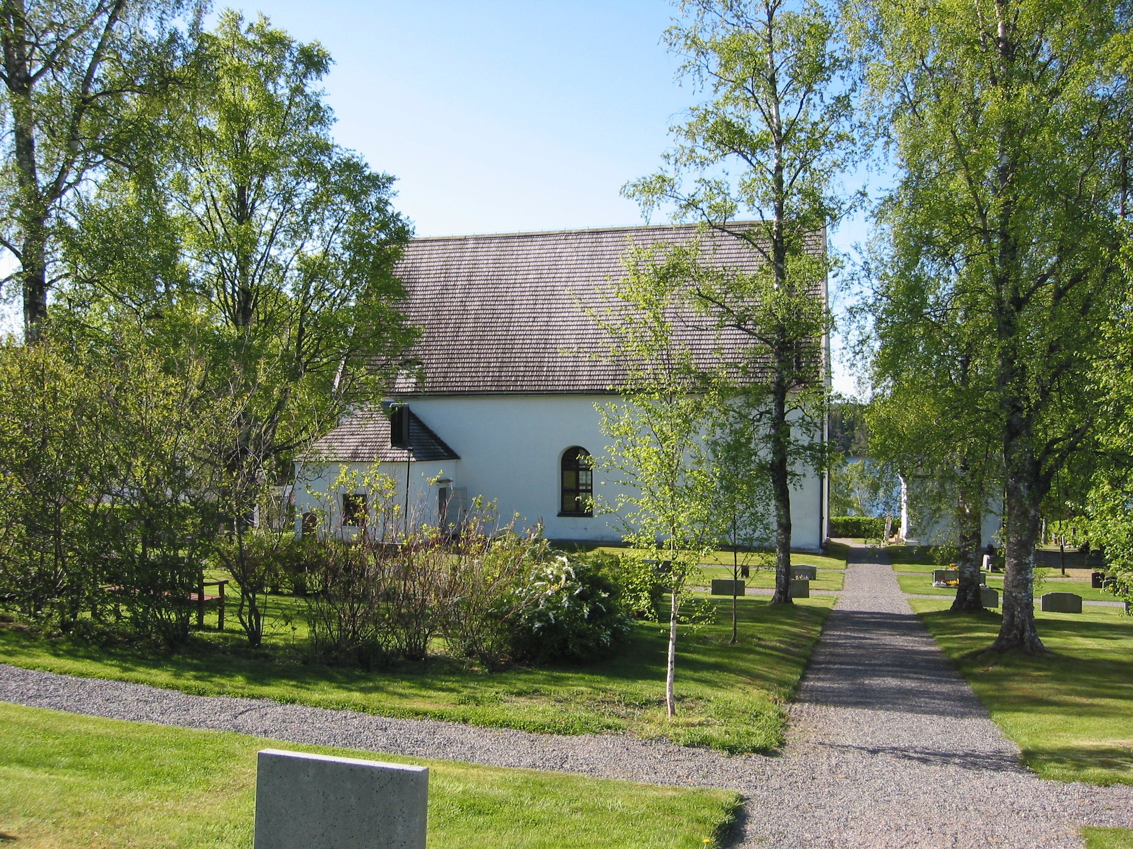 Skogs kyrka med omgivande kyrkogård, vy från nord väst. 