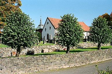 Hajoms kyrka med omgivande terrasserade kyrkogård, från SV.