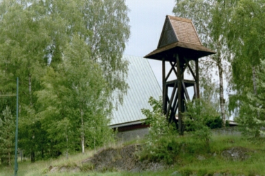 Klockstapeln med Sjöbo kyrka i bakgrunden.