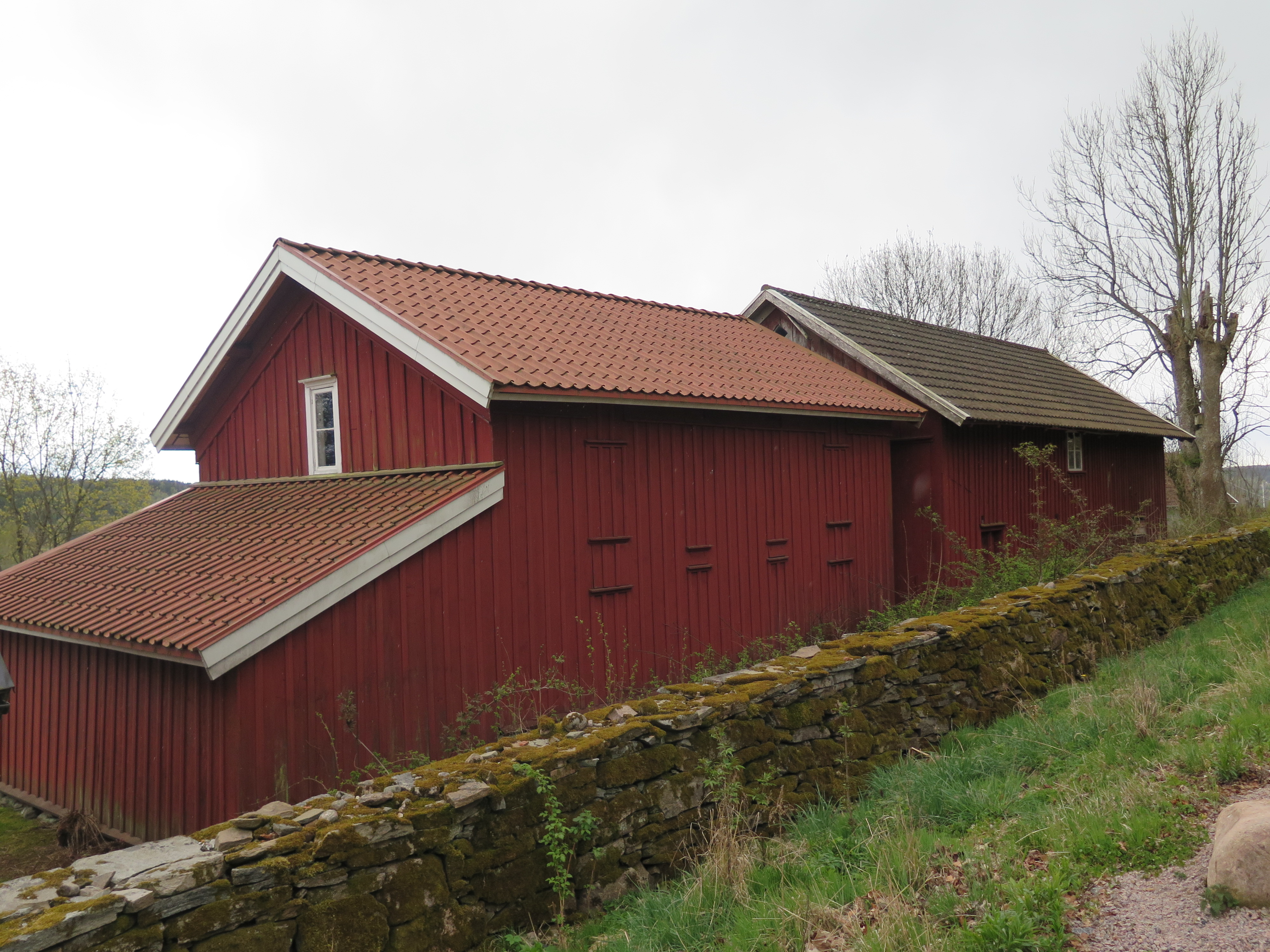 Sockenmagasinet och kyrkstallet sedda ifrån prästgårdstomten i väst. På bilden syns även den lägre tillbyggnaden med pulpettak tillhörande magasinet, som fungerat som förvaring för likvagn. 