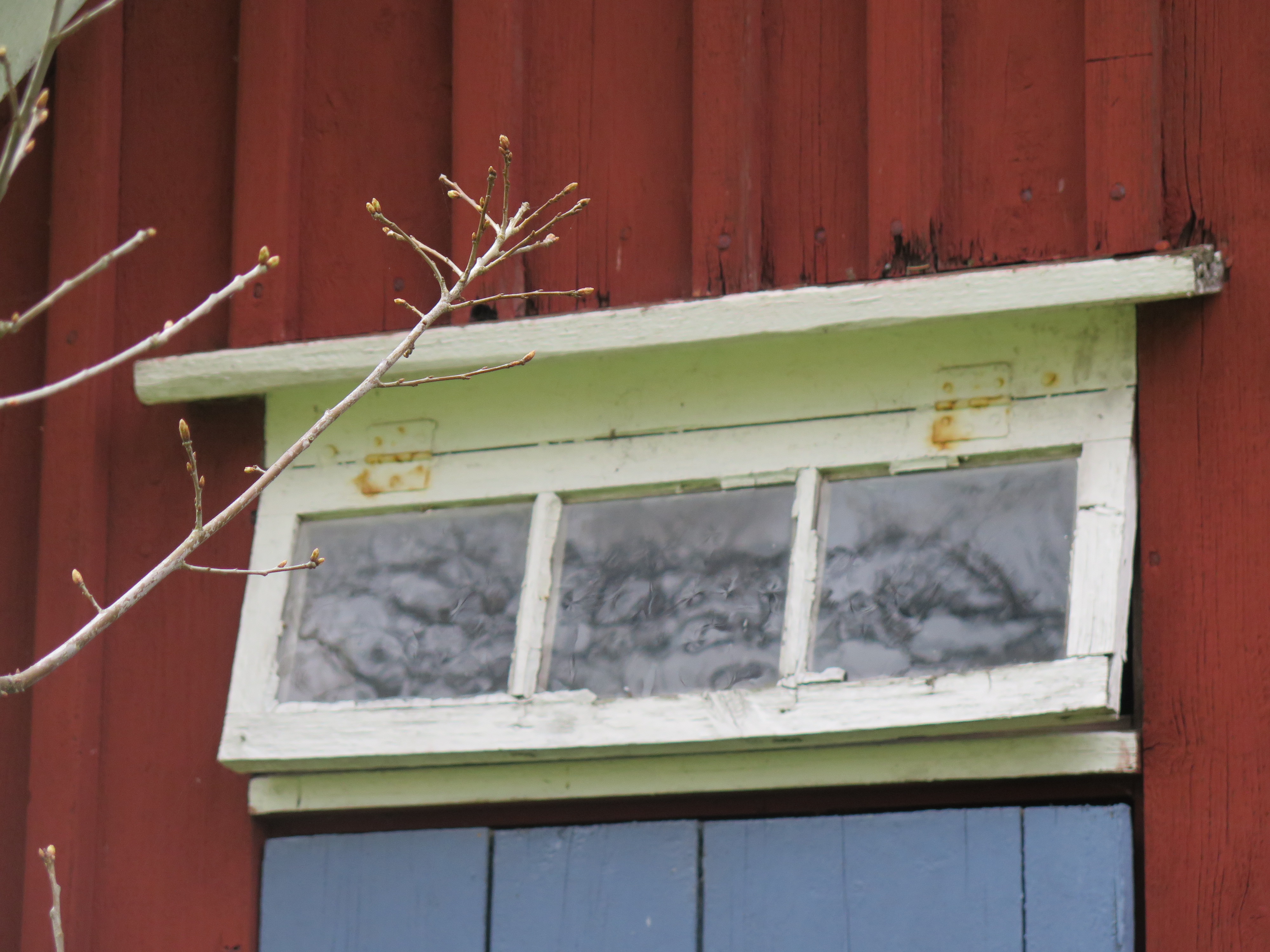 Detaljbild överljusfönster ovanför dörr på gavel.