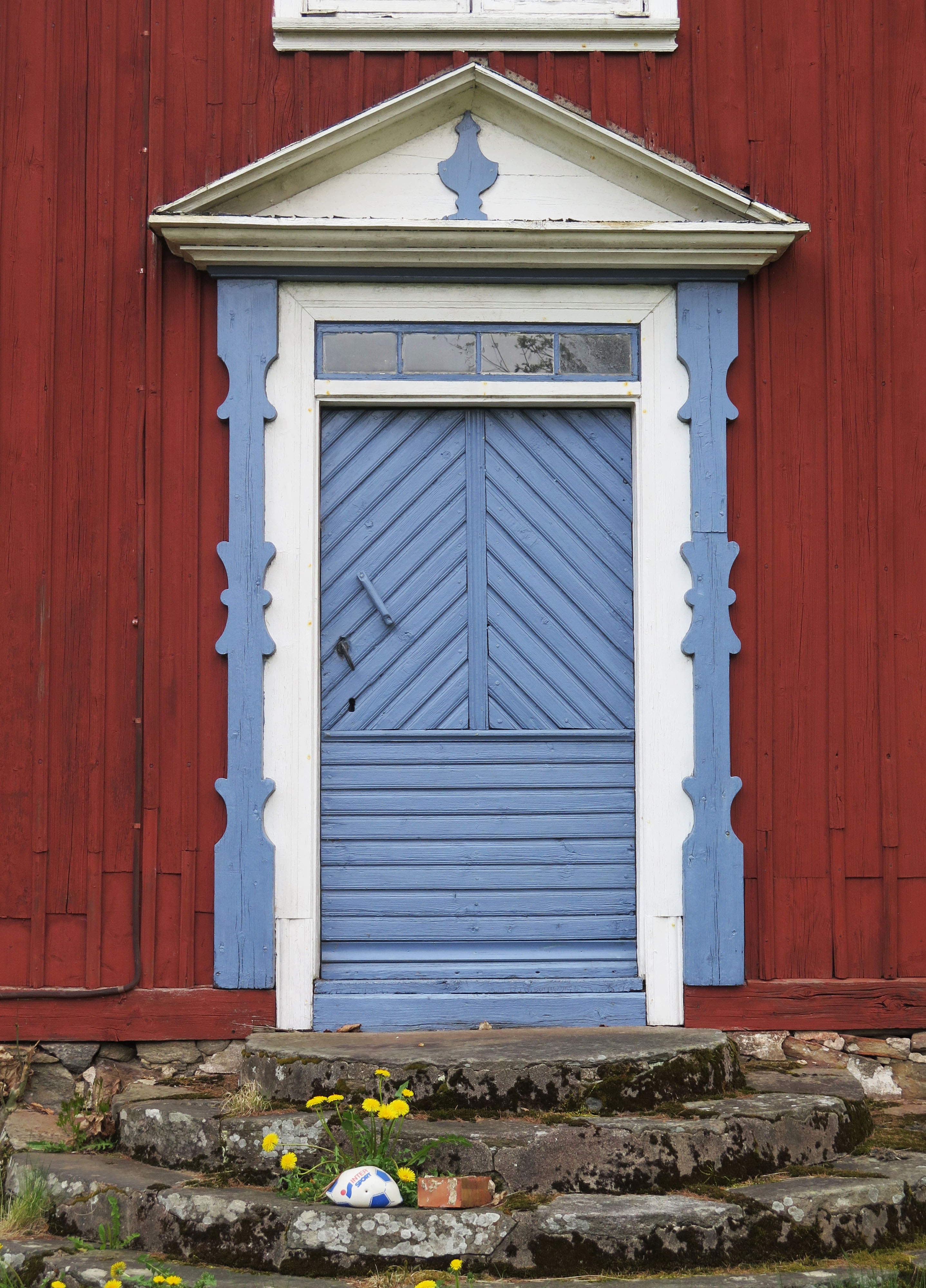 Huvudentréns portal med fronton, pilastrar och överljusfönster.