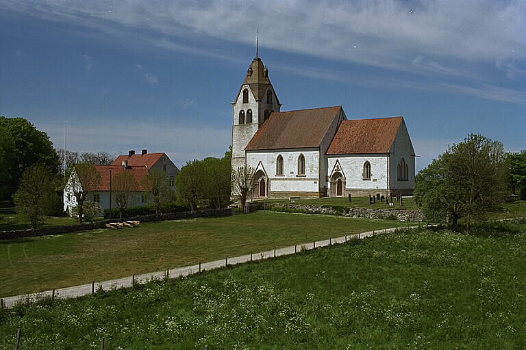 Grötlingbo kyrka från sydöst med prästgården till vänster. 
