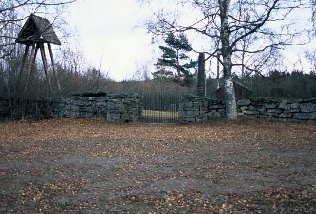 Den gamla kyrkplatsen med klockstapel, minneststen och bevarad sakristiedel.