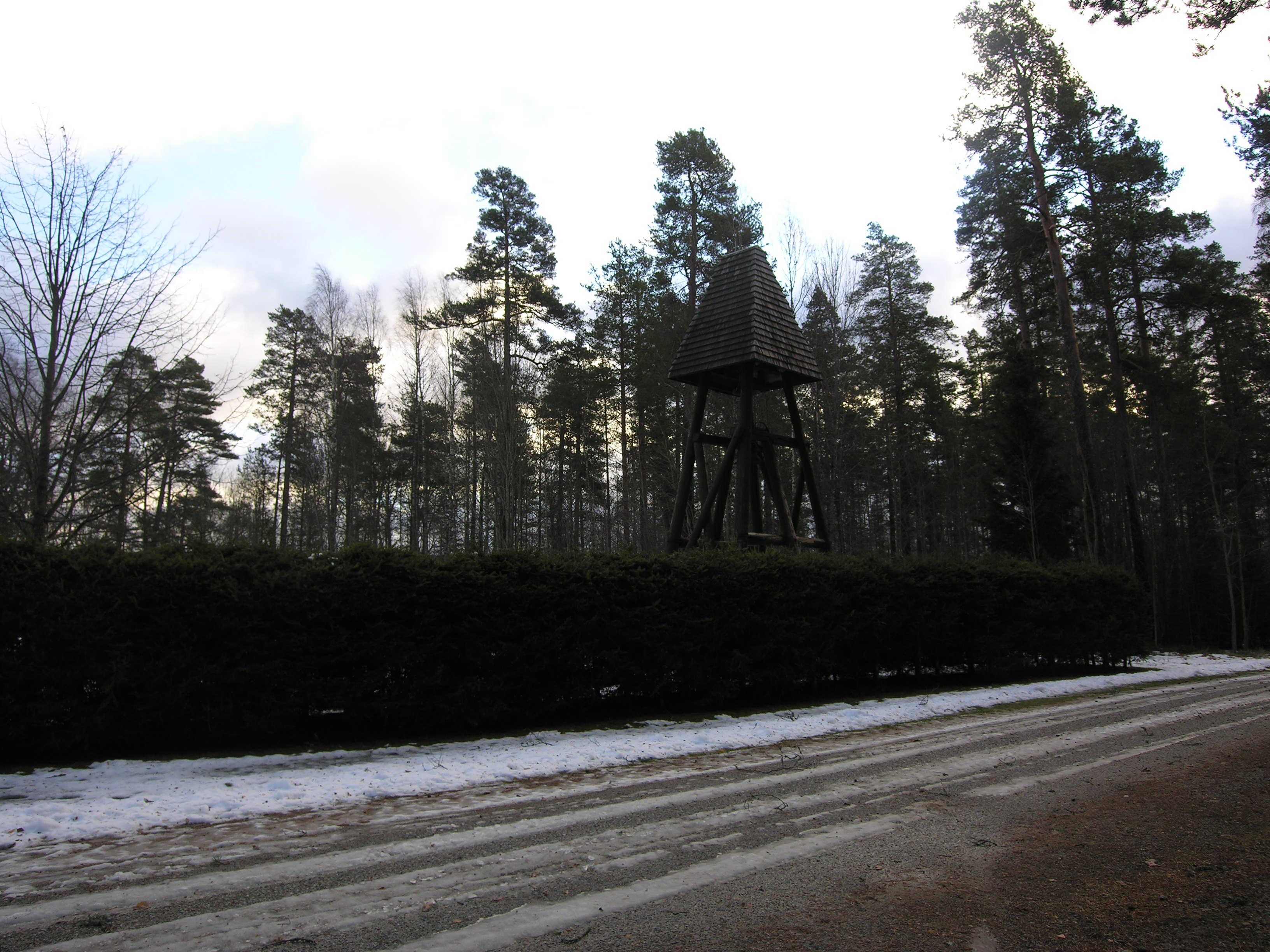 Klockstapeln vid Karlsdals kapell står i det sydvästra hörnet av begravningsplatsen. 
