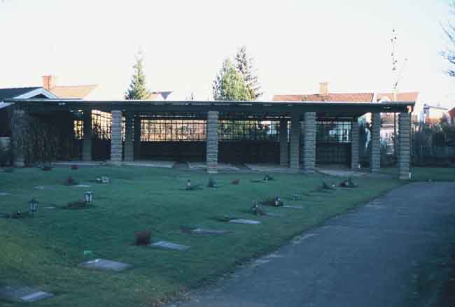 Pergolabyggnad över äldre gravvårdar.