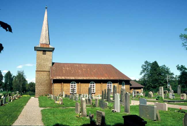 Tveta kyrka från söder med den äldsta delen av kyrkogården.