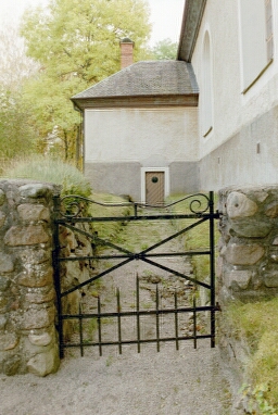 Vassända-Naglums kyrka har en gammal smidesgrind i väster till gången fram till pannrummet under sakristian..