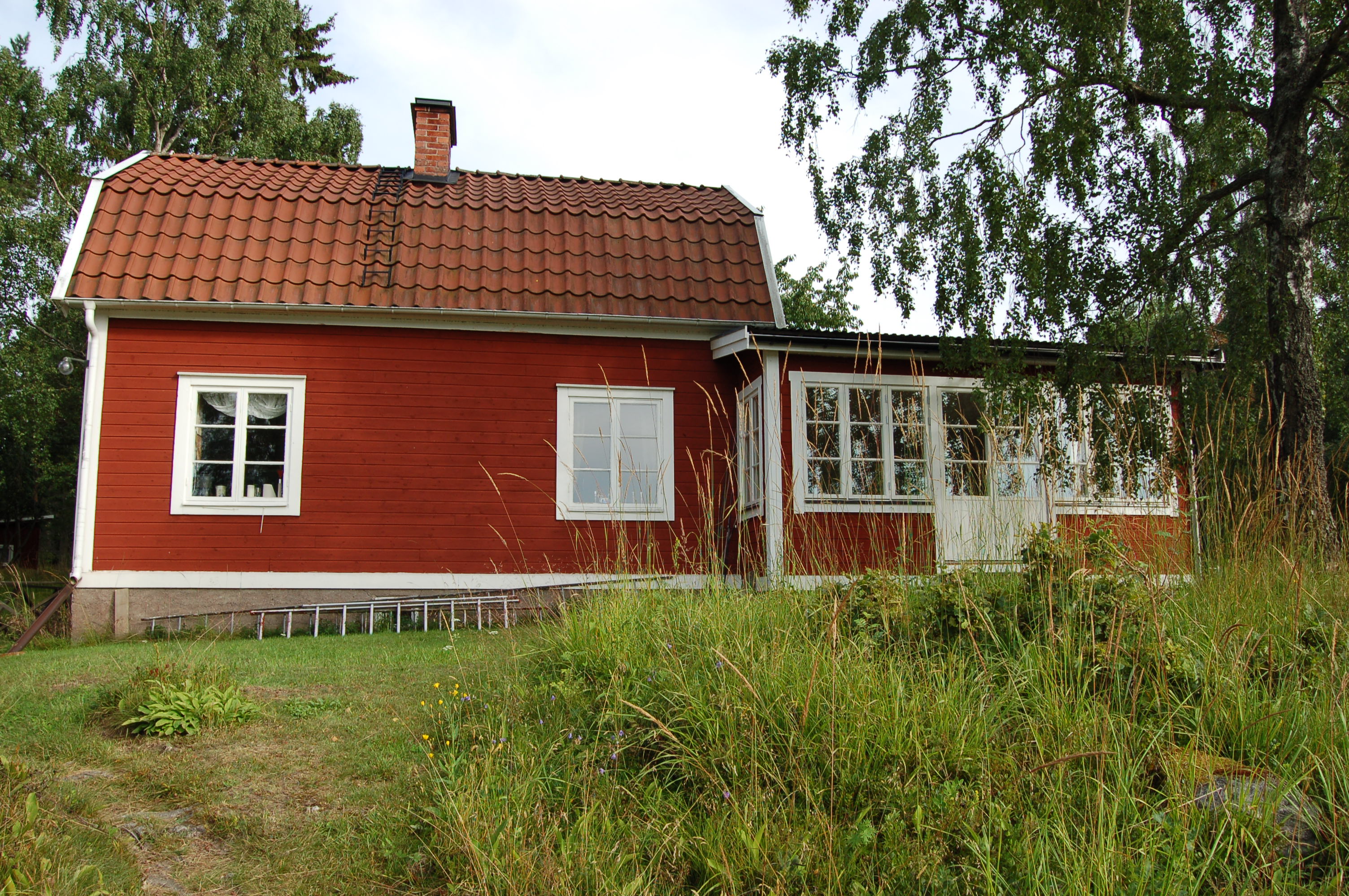 Bostadshus med omgivande trädgård.