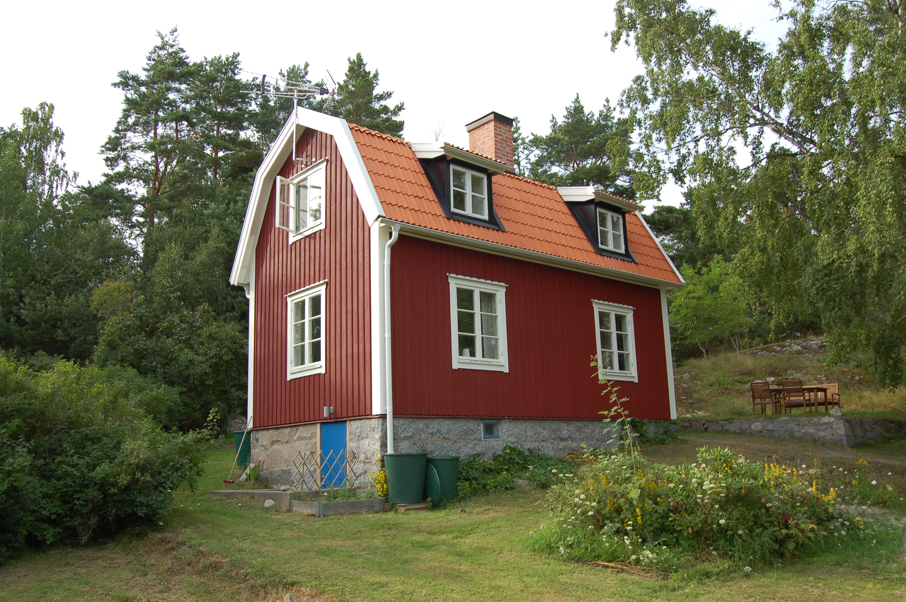 Bostadshuset med omgivande trädgård.