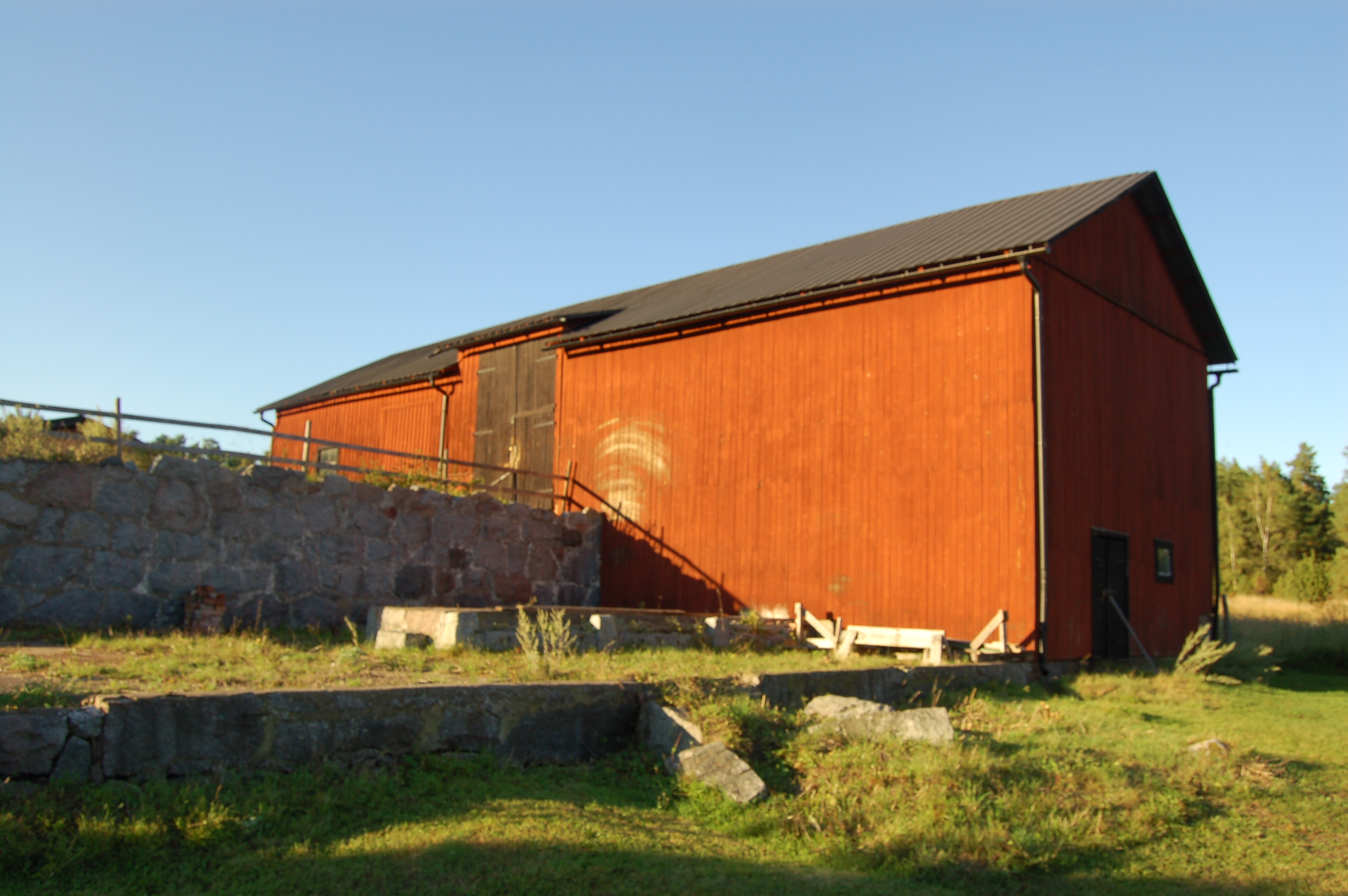 Ladugård med mur framför portarna.