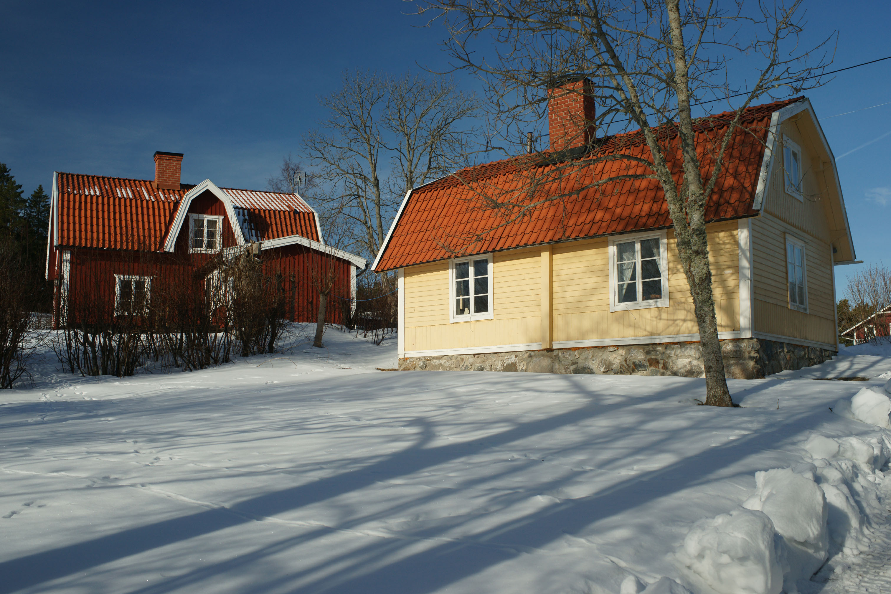 Bostadshus med omgivande trädgård sett från sydöst.